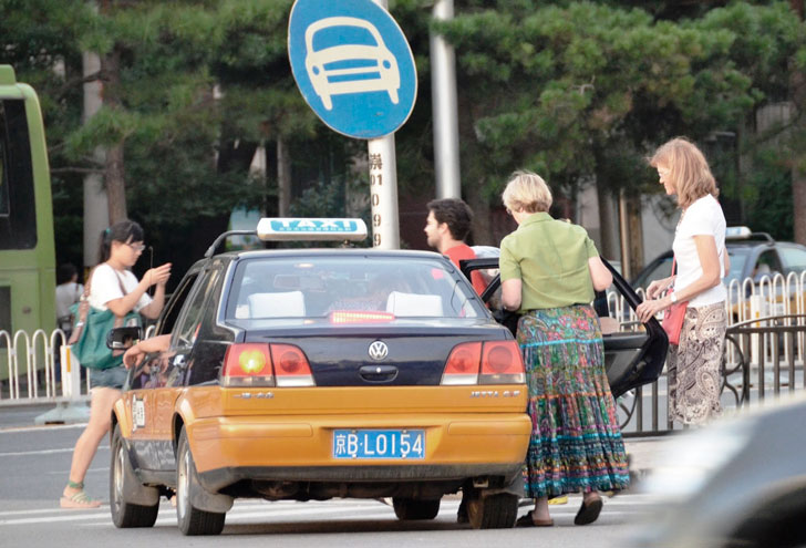 туристы садятся в такси в Китае